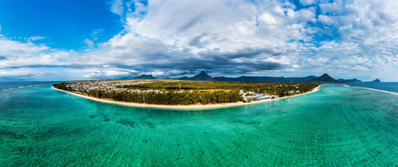 Aerial Landscape view of Flic en Flac beach with cityscape of Flic en Flac town and Mauritius mountain landscape in the background. Best tropical beaches in Flic en Flac, Mauritius island.