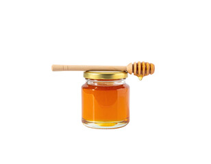A small glass jar filled with golden liquid, topped with a honey dipper, some dripping