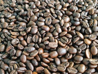 Obraz premium Coffee beans scattered across a surface showing various shapes and colors in a natural