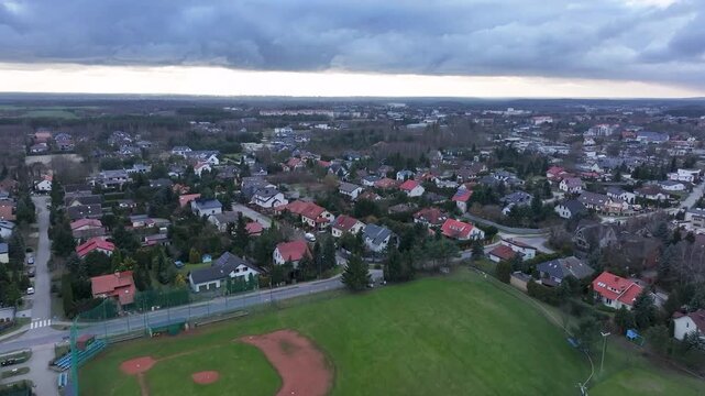 Aerial Osielsko parish city Poland city 4K. Modern city based on historical Polish architecture. Apartment complex, school, sports fields, parks and individual private residential homes.