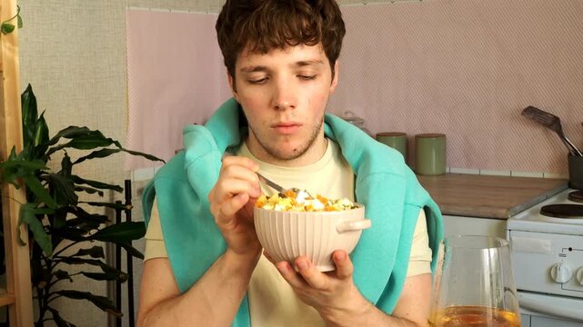 An attractive guy eats a salad for lunch.