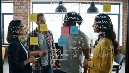 Diverse colleagues brainstorming with colorful sticky notes in modern office - Powered by Adobe