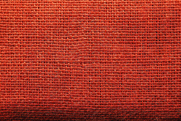 Bright red fabric showing woven texture with small details visible in the light
