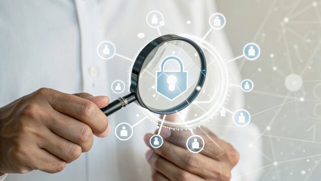 A person holds a magnifying glass over digital security icons, symbolizing search and protection in cybersecurity.