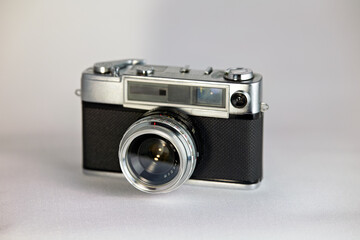 Classic silver and black vintage film camera on a white background, evoking nostalgia for traditional photography. A retro rangefinder perfect for old-school enthusiasts.