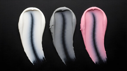 Vibrant makeup brush strokes in white, grey, and pink on black background