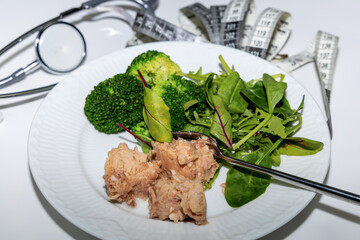 Weight loss nutrition plate with stethoscope and measuring tape