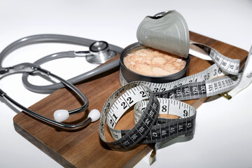 Healthy lifestyle concept tuna can measuring tape stethoscope.