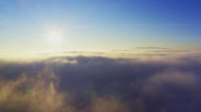 Wonderful view of extraordinary cloudy valley and bright orange sunset