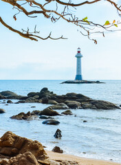 White lighthouse standing on the coastal rocks at Sanya Dongtian Park (Daxiao Dongtian Scenic Area) in Sanya, Hainan, China