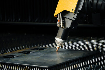 fiber laser cutting machine head with nozzle precisely cutting contours in sheet metal plate for high-precision part fabrication