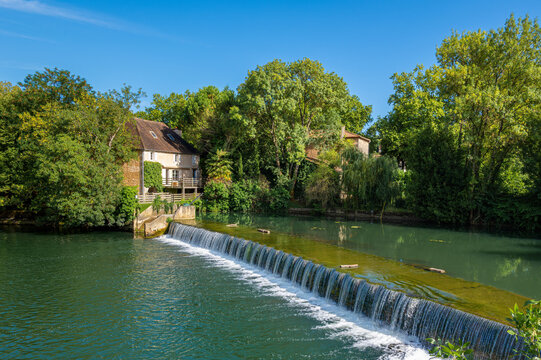Clain river in Poitiers, modern glass structure and lush greenery