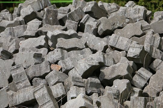 Close-up of grey bricks lying in a pile in the garden