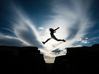 Silhouette of a person leaping across a chasm against a bright sky