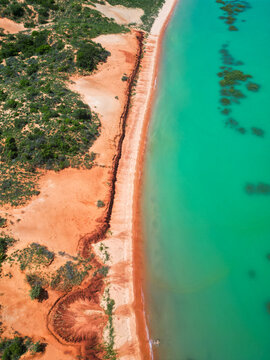 Arial view of Simpson Beach in Broome, Western Australia, showcasing turquoise waters, white sand coastline and tropical landscape in the Kimberley region captured by drone