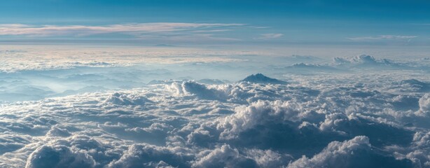 Naklejka premium High-altitude view of vast, fluffy clouds, with hints of mountains