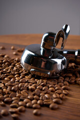 A coffee holder lies on a wooden table among coffee beans                               