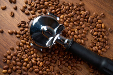 A coffee holder lies on a wooden table among coffee beans                               