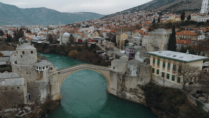 Aerial view of the historic stone bridge over the Neretva River in Mostar, with old town...