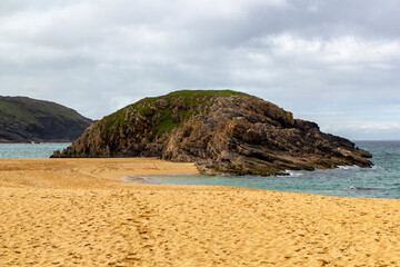 Fototapeta premium panoramic view around the famous, murder hole beach in ireland at a cloudy windy summer day