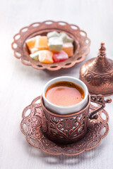 Traditional turkish coffee and turkish delight on wooden table painted white.