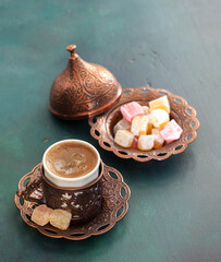 Traditional turkish coffee and turkish delight on wooden table painted green.