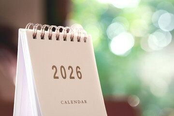 Small white calendar year 2026 on wooden table, with copy space.
