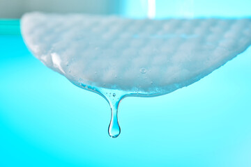 Skincare liquid dripping from a cotton pad © Marevgenna