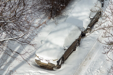 cars covered in snow on the street