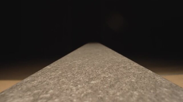 Granular material forming a conical pile on a flat surface. Fine sand slowly heaps up, demonstrating the angle of repose and physics concepts