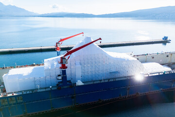 Aerial view of a luxury yacht refit, repair, service and maintenance in a floating dock at a marina.