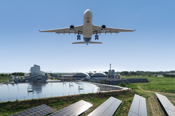 An airplane flies over a biogas plant. A symbol of decarbonization and carbon neutrality in transport.
