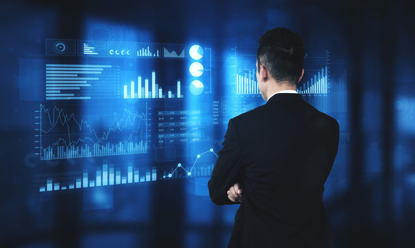 A businessman stands in a modern office, analyzing interactive data visualizations on a digital screen. The futuristic environment enhances his strategic decision-making process. Scalp - Powered by Adobe