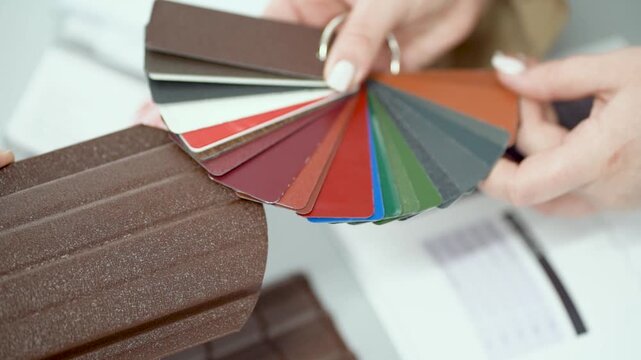 The factory of metal roofing production shows the client different color coatings available for roof sheets. variety of finishes, textures, protective layers used in modern roofing materials.