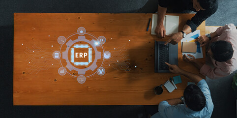 A diverse team engages in a business meeting focused on discussing ERP implementation strategies. They analyze data from a laptop, emphasizing collaboration and innovation. Trope