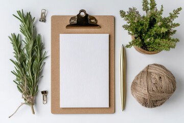 Flat lay of a clipboard with blank paper rosemary a plant a pen and twine on a white background