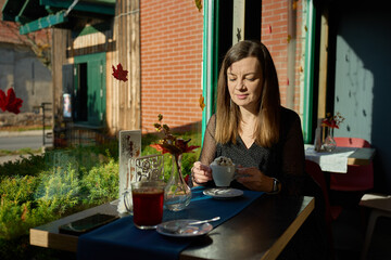 Woman sitting by window in cafe with cup of coffee