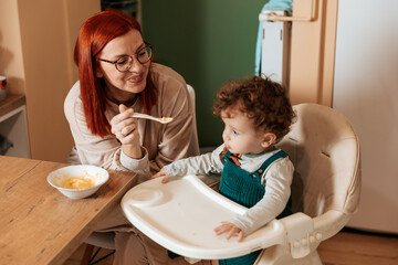 Mother Feeding Her Toddler  in the Kitchen