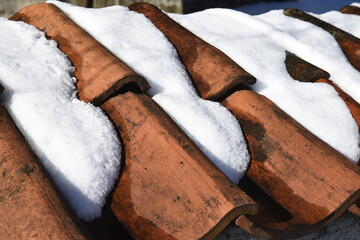 Snow on roof tiles in winter