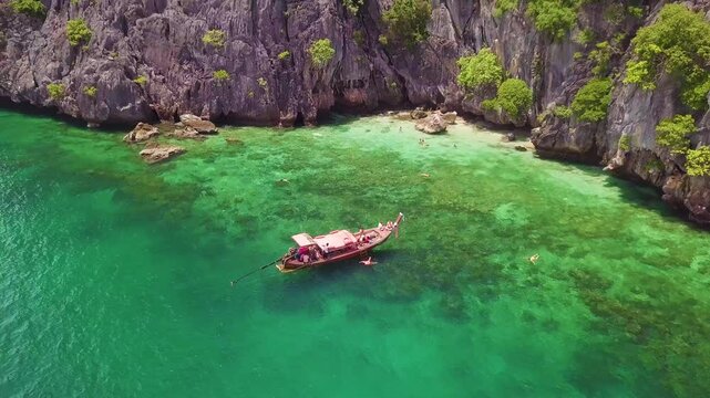 Aerial 4K view of Ko Maa tropical island boat at a snorkeling spot in Thailand