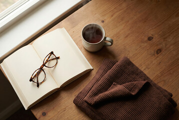 Cozy Flat Lay with Book, Glasses, Tea, and Blanket by Window