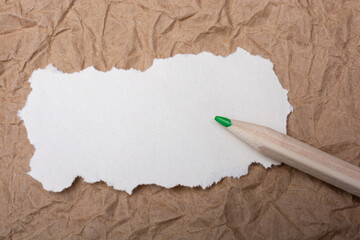 Wooden color pencil and blank white torn paper