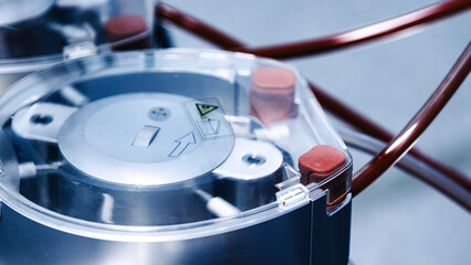 Medical device in a surgical operating room, featuring advanced technology with clear casing and red tubing, highlighting precision and innovation in healthcare procedures