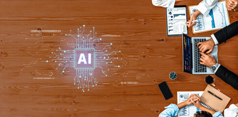 A modern business team collaborating on AI projects, featuring a laptop and digital data graphics on a wooden table, highlighting teamwork and innovation. Trope