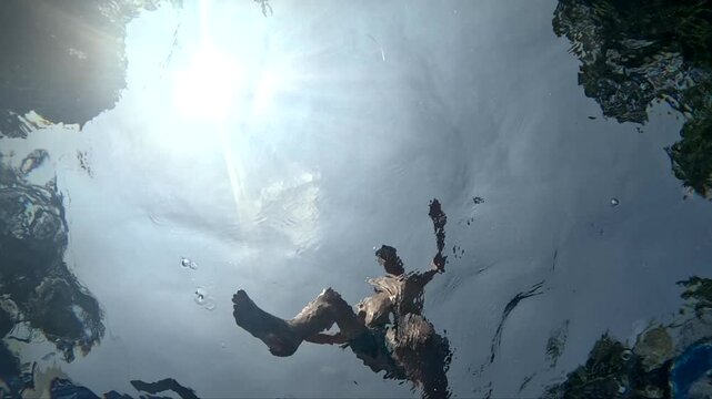 Underwater shots of people swimming in clear water during daytime