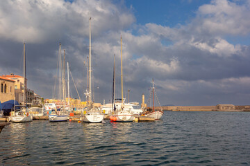 Docked sailing yachts in the Venetian Harbor in Chania, Crete, Greece with cloudy sky