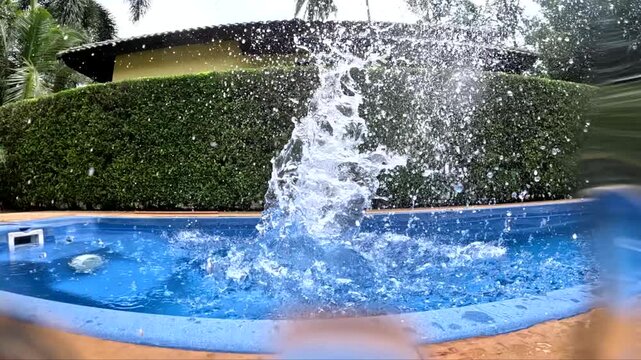 Water splashes from pool activity during sunny afternoon