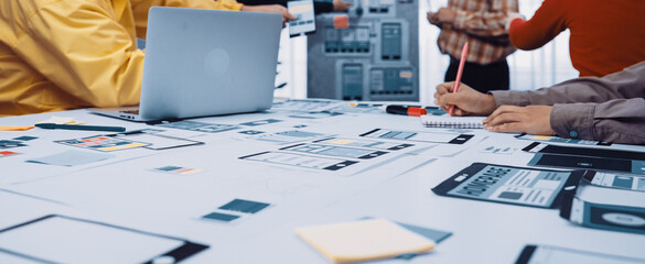 A dynamic team engaged in user interface design, surrounded by sketches, sticky notes, and a laptop, representing innovation and collaboration in a modern workspace. SACTR