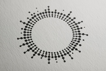 close-up image of a black circular geometric pattern composed of raised dots, printed on textured white paper. The design appears modern and symmetrical