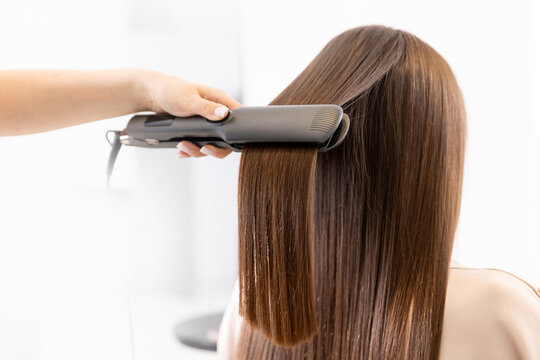 Close up Pulling strands of hair with professional ultrasonic iron tool. Spa care, Keratin straightening and restoration